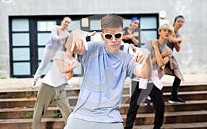Teen boy dancing modern street dance with teenagers