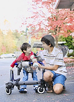 Teen boy with disabled little brother in walker