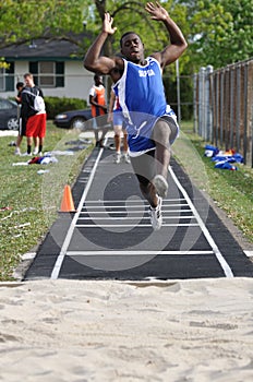 Teen Boy Doing Long Jump at Track and Field Meet