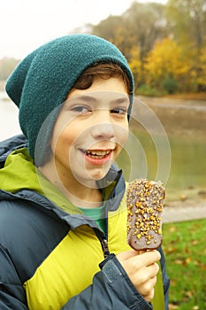 Teen boy eating eskimo icecream and smile