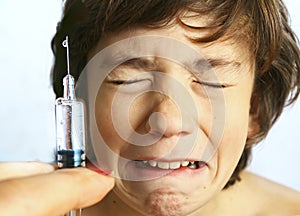 Teen boy in fear of injection.