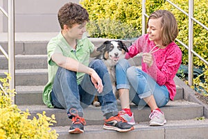 Teen boy and girl playing with puppy