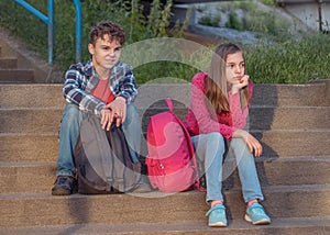 Teen boy and girl sitting on stairs