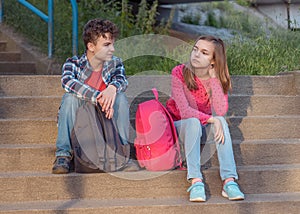 Teen boy and girl sitting on stairs