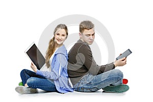 Teen boy and girl sitting with tablets