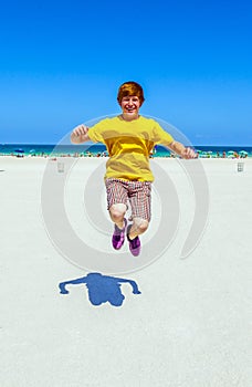 Teen boy jumping in the air at the beach