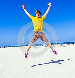 Teen boy jumping in the air at the beach