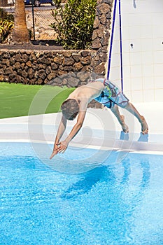 Teen boy jumping in the blue pool