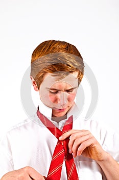 Teen boy knots his tie