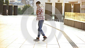 Teen boy moonwalking on street, holding skate, adolescent hobbies and activities