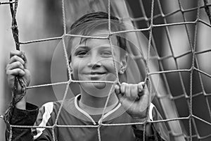 A teen boy near a goal on the soccer field..