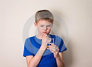Boy observing a half full or half empty glass of water.