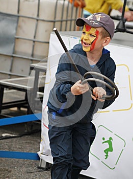 Teen boy with a painted under hero comic book marvel iron man face playing in the Playground municipal Park