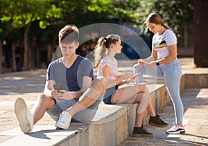 Teen boy with phone on summer city street