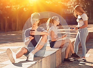 Teen boy with phone on summer city street