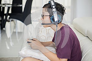 Teen boy playing video games with a joystick