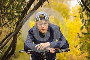 Teen boy resting on a bicycle handle bar