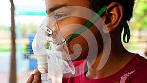 Teen boy side view shot wearing Oxygen supply Canula with during covid 19 pandemic.  photo