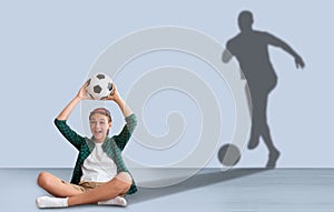 Teen boy with soccer ball dreaming about football player career