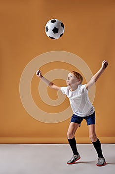 teen boy soccer player kicking ball with head