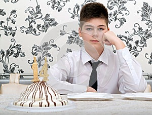 teen boy at table with cake for his fourteenth birthday