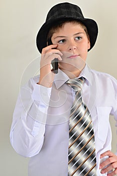 Teen boy talking on cell phone at light background