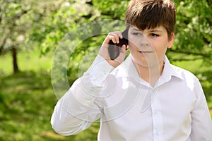 Teen boy talking on phone outdoors