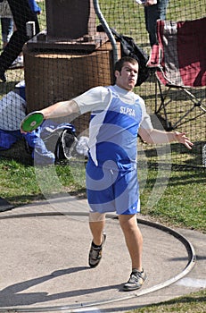 Teen Boy Throwing Discus at High School Track Meet