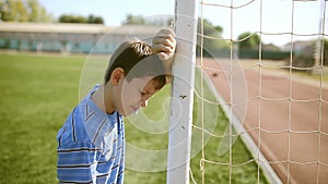 Teen boy upset defeat by knocking goal goal post