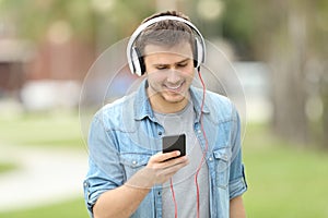 Teen boy walking and listening on line music