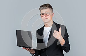 teen boy wear formal suit and glasses use laptop, education