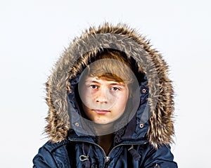 Teen boy wearing an anorak with fake fur around the hood