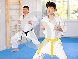 Teen boy wearing kimono training karate techniques during workout session