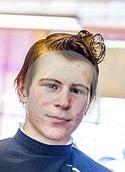 Teen boy with wet hair in the hairdressing salon
