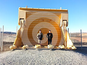 Teen Boys standing in huge mining excavator bucket