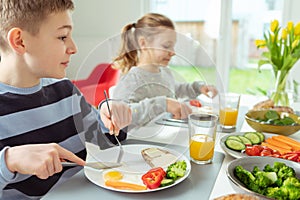 Teen brother and sister eating healthy breakfast at home