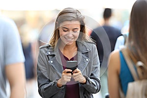 Teen chatting on smart phone surrounding by people