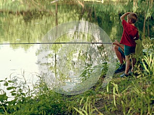 Teen child catches a fishing rod on the pond