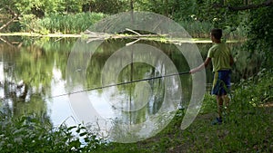 Teen child catches a fishing rod on the pond.