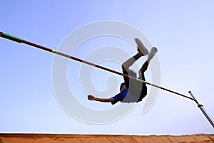 Teen clearing high jump bar