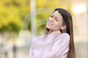 Teen complaining due neck ache in a park