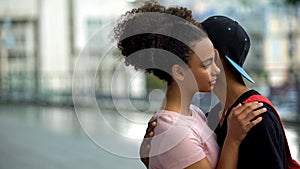 Teen couple of teenagers hugging during outdoor date, love connection affection