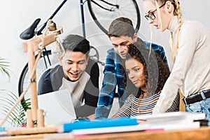 teen friends watching something on laptop