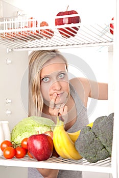 Teen with fruit in fridge