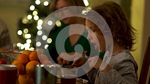 Teen gently eats with a knife and fork. Family Christmas Dinner. Rules of etiquette, behavior at the table. Romantic