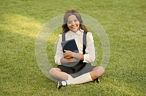 teen girl with book on green grass. pretty child little girl read book. study literature for children. having fun with