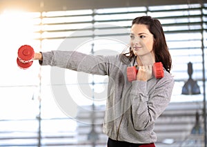 Teen girl boxing with hand barbell