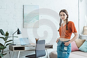 teen girl with braids standing near table