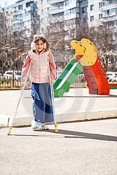 teen girl with a broken leg on crutches in the playground.