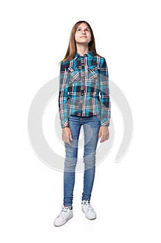 Teen girl in checkered shirt standing casually looking up